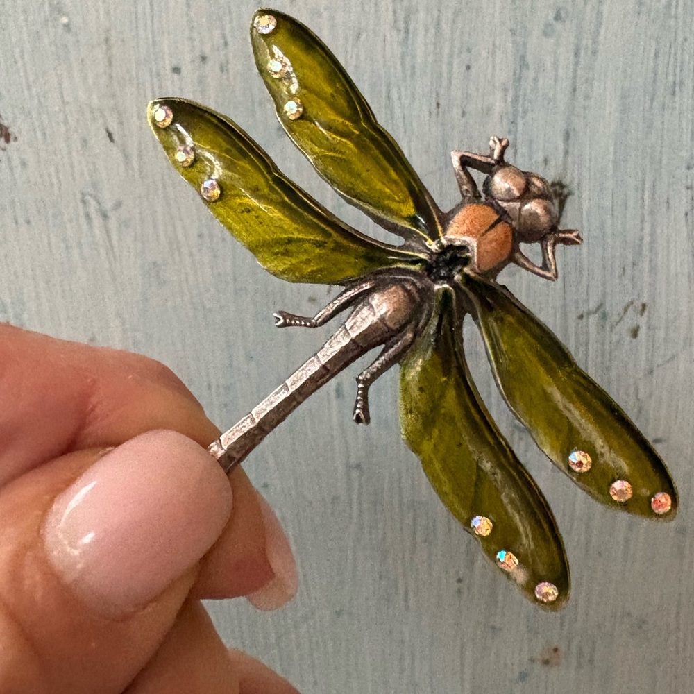 Green enamel dragonfly pin with rhinestones on its wing tips and peach body